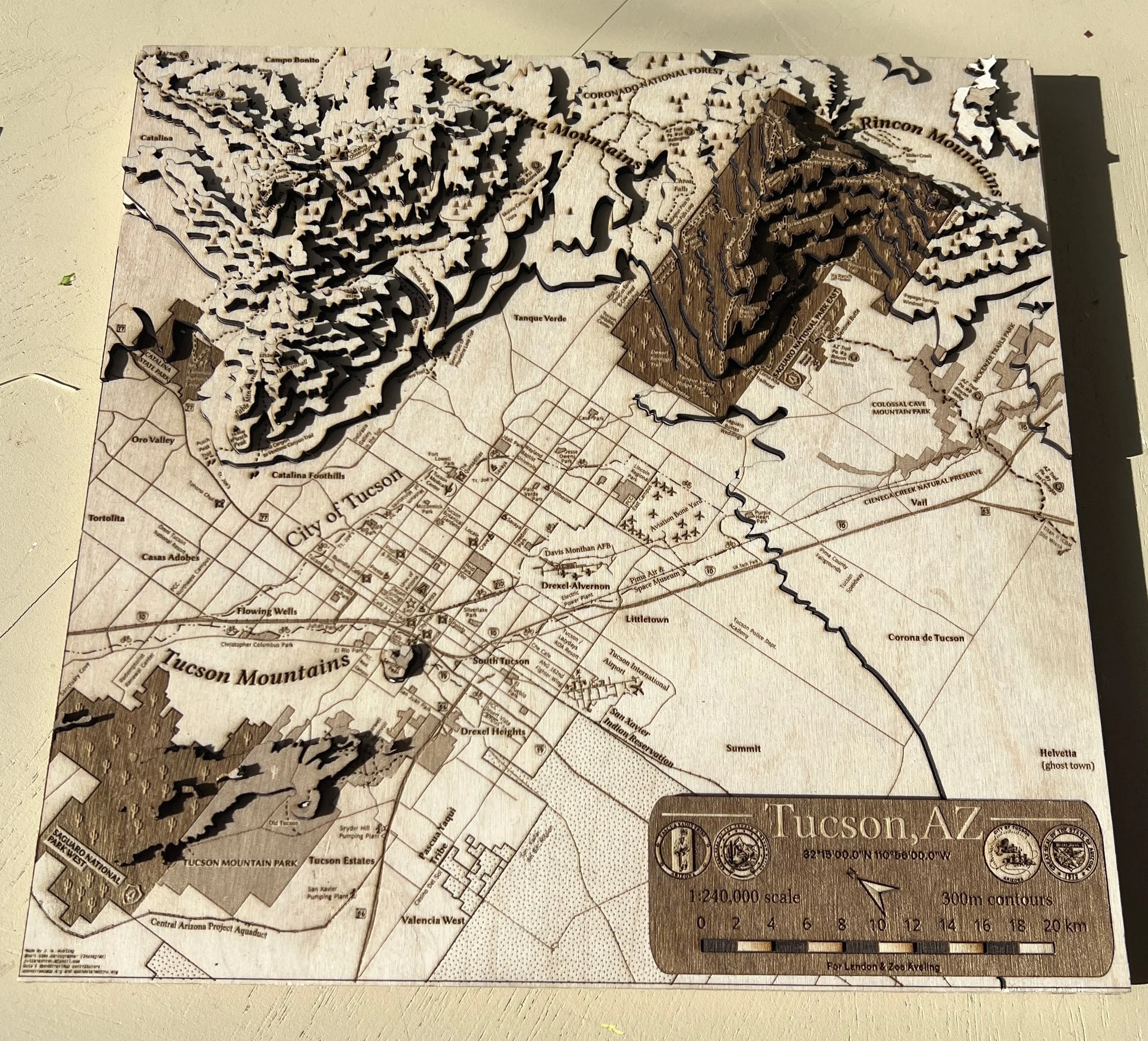 The same Tucson V.2 map from a similar angle, showing the contrast between the detailed flat city engraving and the dimensional mountain terrain. A title plaque in the corner indicates that the scale is 1:240,000.